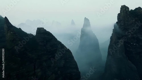 A sense of foreboding surrounds the foggy rock formations making them appear even more imposing and enigmatic.
