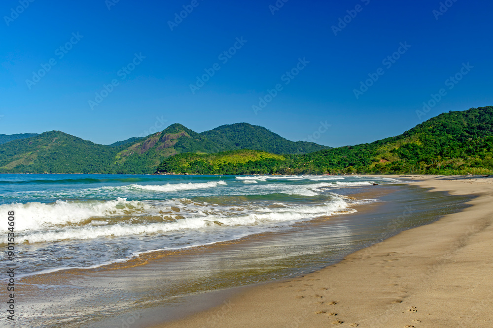 Obraz premium Panoramic image of Bonete beach in Ilhabela with the sea, hills and forests surrounding it