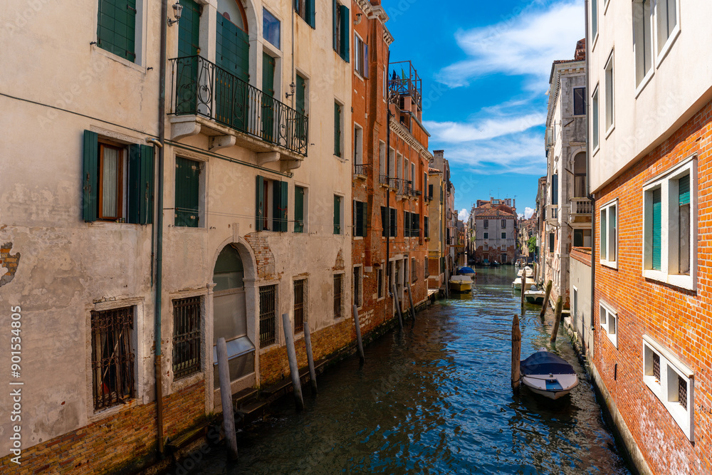 Venice, Italy - June 04, 2024: Peaceful Venice Canal Framed by Colorful Buildings. Venice, Italy - June 04, 2024: Peaceful Venice Canal Framed by Colorful Buildings.