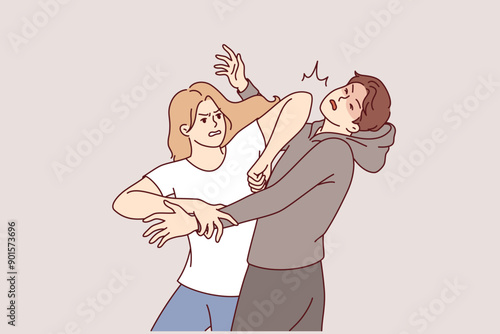 Woman demonstrates self-defense technique by striking man in face pretending to be maniac or robber. Self-defense lessons for girls who want to have sense of security when meeting attacker
