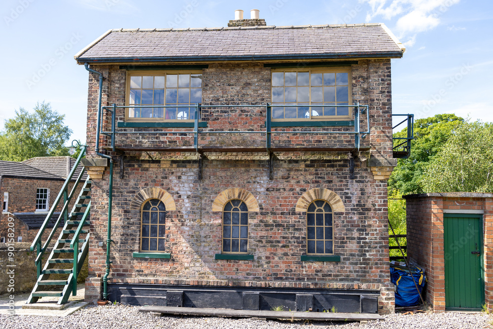 Photo of the beautiful town of Bedale, which is a market town and civil parish in North Yorkshire, England showing an old historical train signal house along side the train tracks in the town