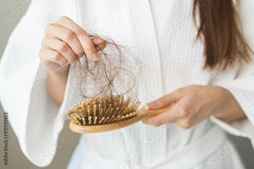 Stress asian young woman, girl hand holding comb show her hairbrush with loss, hair in brush after brushing, hair fall out problem. Health care, beauty with treatment concept, isolated on background. photo