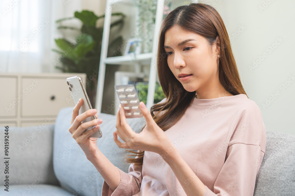 Health care asian young woman using smart phone for reading, searching prescription on bottle medicine, pill label text about information online, instructions side effects, pharmacy medicament concept Health care asian young woman using smart phone for reading, searching prescription on bottle medicine, pill label text about information online, instructions side effects, pharmacy medicament concept