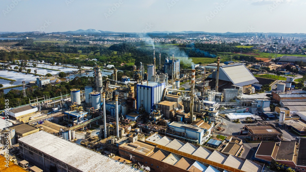 Visão aérea de chaminés e equipamentos soltando vapores e poluentes em uma indústria de papel e celulose em suzano, são paulo, brasil