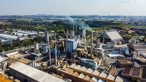 Obraz na płótnie Visão aérea de chaminés e equipamentos soltando vapores e poluentes em uma indústria de papel e celulose em suzano, são paulo, brasil w salonie