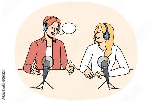 Radio show hosts sit around table with microphones discussing latest news preparing online podcast. Man and woman work as radio announcers and create audio broadcast in sound recording studio.