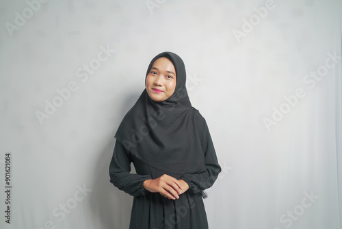 A young woman in a black hijab, smiling and looking at the camera. photo