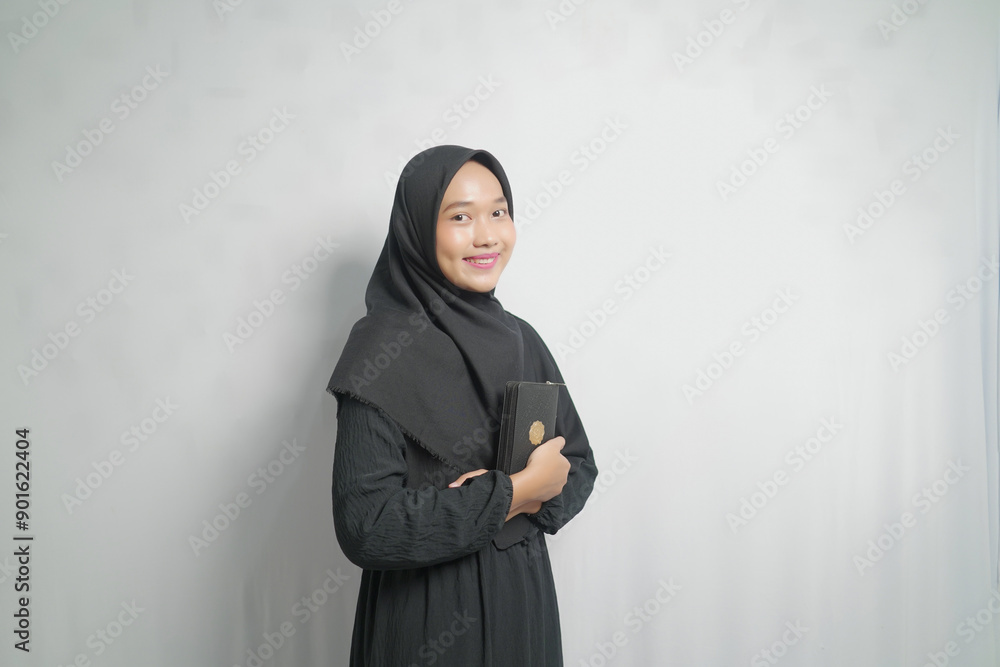 Smiling Woman in Black Hijab Holding a Quran Smiling Woman in Black Hijab Holding a Quran
