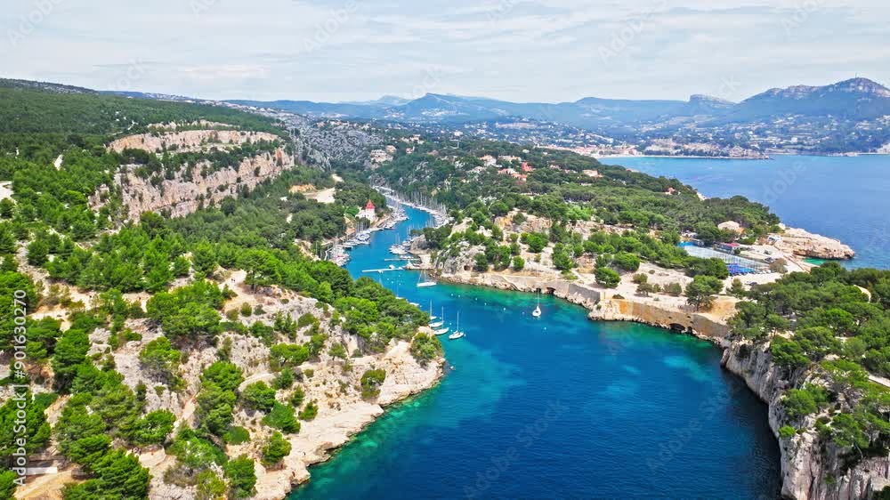 Aerial view of Tourist attraction beach, people enjoying summer vacation in Parc du Mugel, France. Snug Cove framed by rugged cliffs, with calm swimming off a pebble beach, and turquoise clear water. Aerial view of Tourist attraction beach, people enjoying summer vacation in Parc du Mugel, France. Snug Cove framed by rugged cliffs, with calm swimming off a pebble beach, and turquoise clear water.