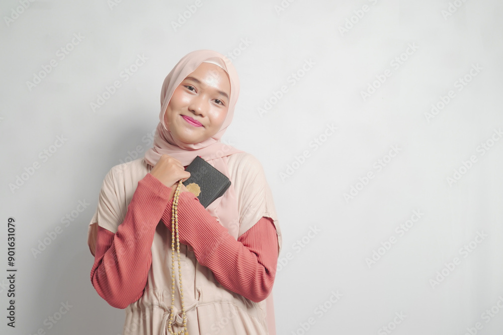 Muslim woman in hijab holding a Quran and Tasbih beads Muslim woman in hijab holding a Quran and Tasbih beads