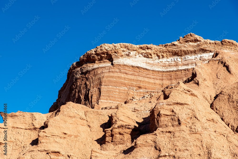 Close up low angle view of rock formation with salt sediment in Valle de la Luna (Valley of the Moon) in Atacama Desert near San Pedro de Atacama, Antofagasta, Chile against a blue sky Close up low angle view of rock formation with salt sediment in Valle de la Luna (Valley of the Moon) in Atacama Desert near San Pedro de Atacama, Antofagasta, Chile against a blue sky