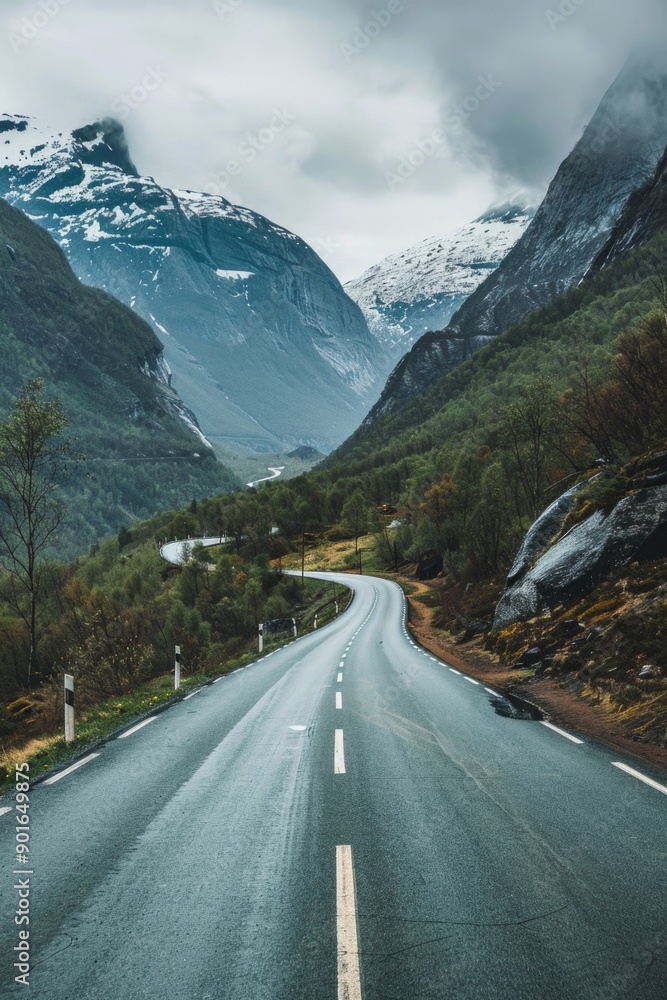A long road with a mountain range in the background. The road is wet and the sky is cloudy A long road with a mountain range in the background. The road is wet and the sky is cloudy