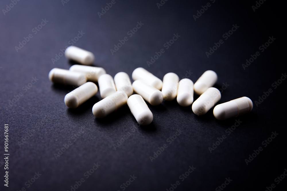 Creatine capsules on dark paper background. Soft focus. Copy space. Creatine capsules on dark paper background. Soft focus. Copy space.