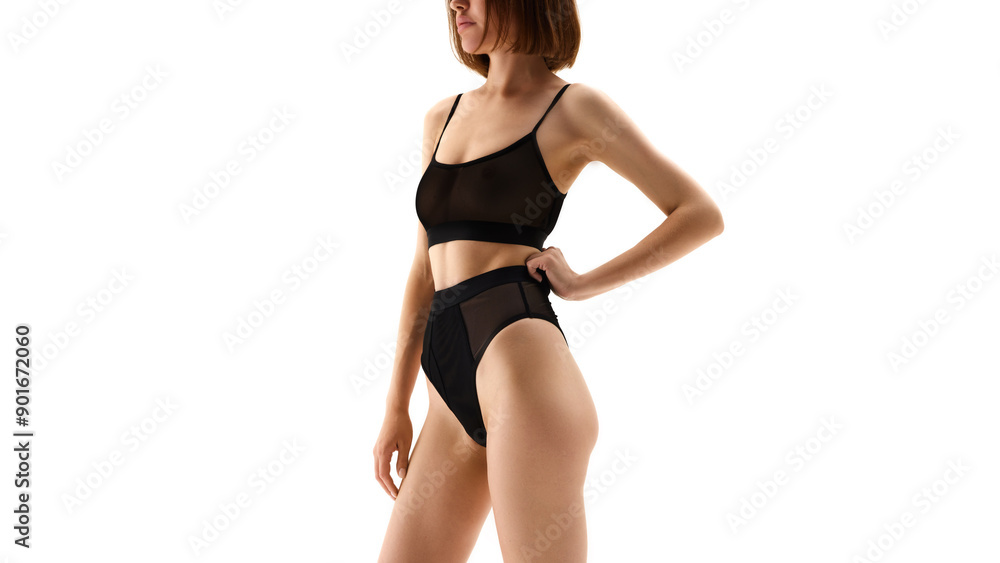 Cropped side view image of young skinny woman with short hair, slim body shape posing in black underwear isolated on white studio background. Concept of female beauty, body and health care, sport Cropped side view image of young skinny woman with short hair, slim body shape posing in black underwear isolated on white studio background. Concept of female beauty, body and health care, sport