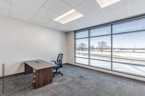 Modern office with a comfortable chair and large window providing a bright and ergonomic workspace. photo