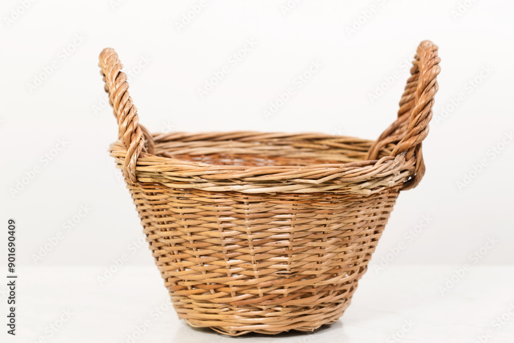 Obraz premium Empty wicker basket with two handles, low angle shot