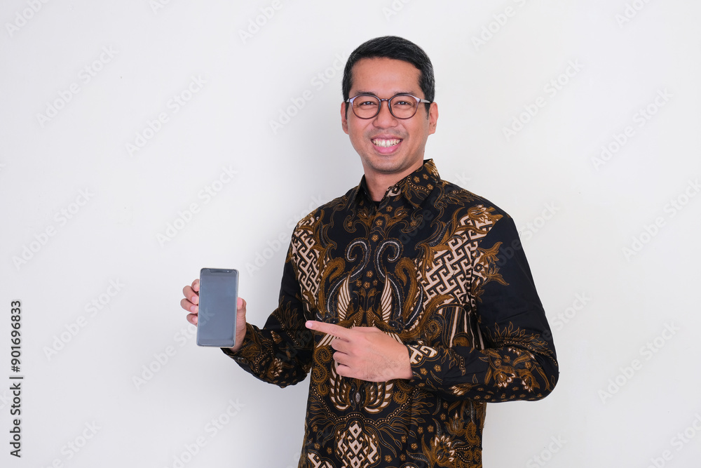 Adult Asian man smiling proud while pointing to blank mobile phone screen that he hold Adult Asian man smiling proud while pointing to blank mobile phone screen that he hold