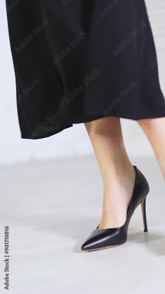 Elegant classic black shoes demonstration. Woman in long black skirt showing the high-heeled stiletto footwear. White backdrop. Vertical video Elegant classic black shoes demonstration. Woman in long black skirt showing the high-heeled stiletto footwear. White backdrop. Vertical video