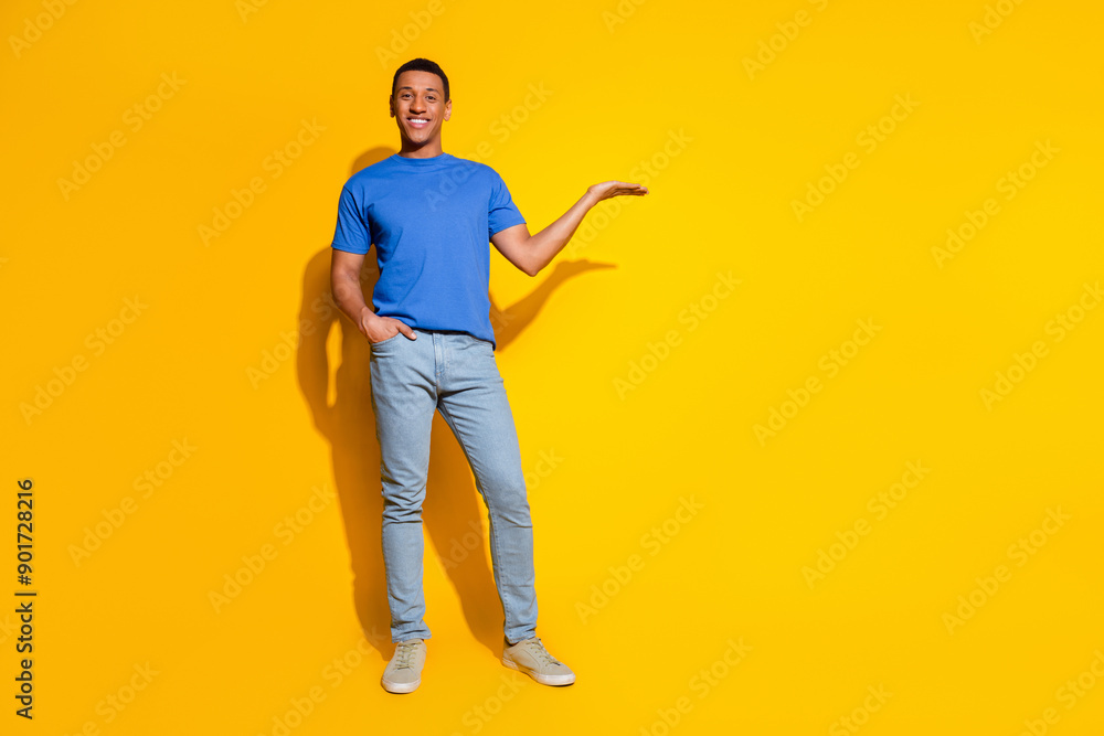 Fototapeta premium Full size photo of pretty young male hold empty space wear trendy blue outfit isolated on yellow color background