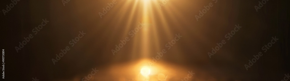 Naklejka premium Golden light beam spotlight. A bright golden spotlight shines on a dark background, creating a dramatic and atmospheric effect.