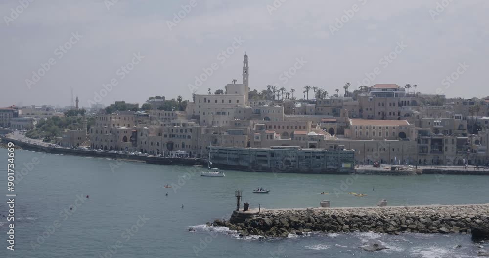 Aerial shots of a group rowing kayaks leaving the beautiful old port of Jaffa, a sailboat sailing in the background. Aerial shots of a group rowing kayaks leaving the beautiful old port of Jaffa, a sailboat sailing in the background.