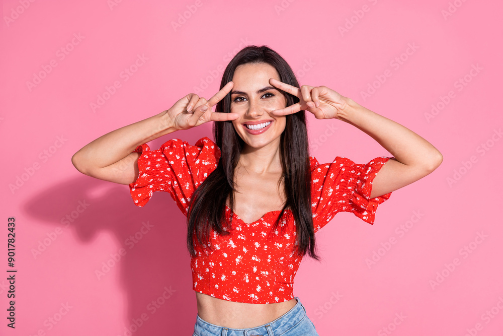Portrait of smiling beautiful gorgeous lovely young woman in retro red blouse cover face double v sign isolated on pink color background Portrait of smiling beautiful gorgeous lovely young woman in retro red blouse cover face double v sign isolated on pink color background
