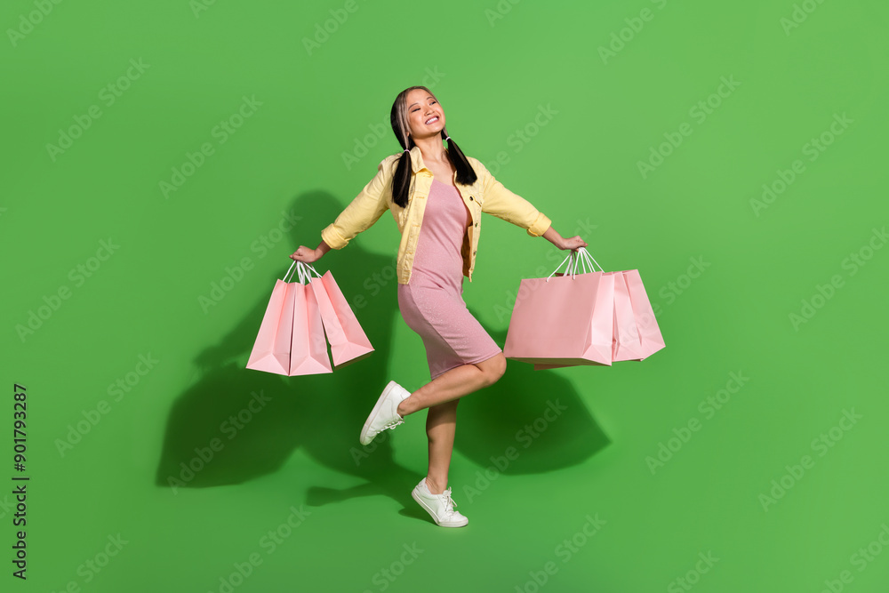 Full body portrait of pretty young woman bags empty space wear jacket dress isolated on green color background Full body portrait of pretty young woman bags empty space wear jacket dress isolated on green color background
