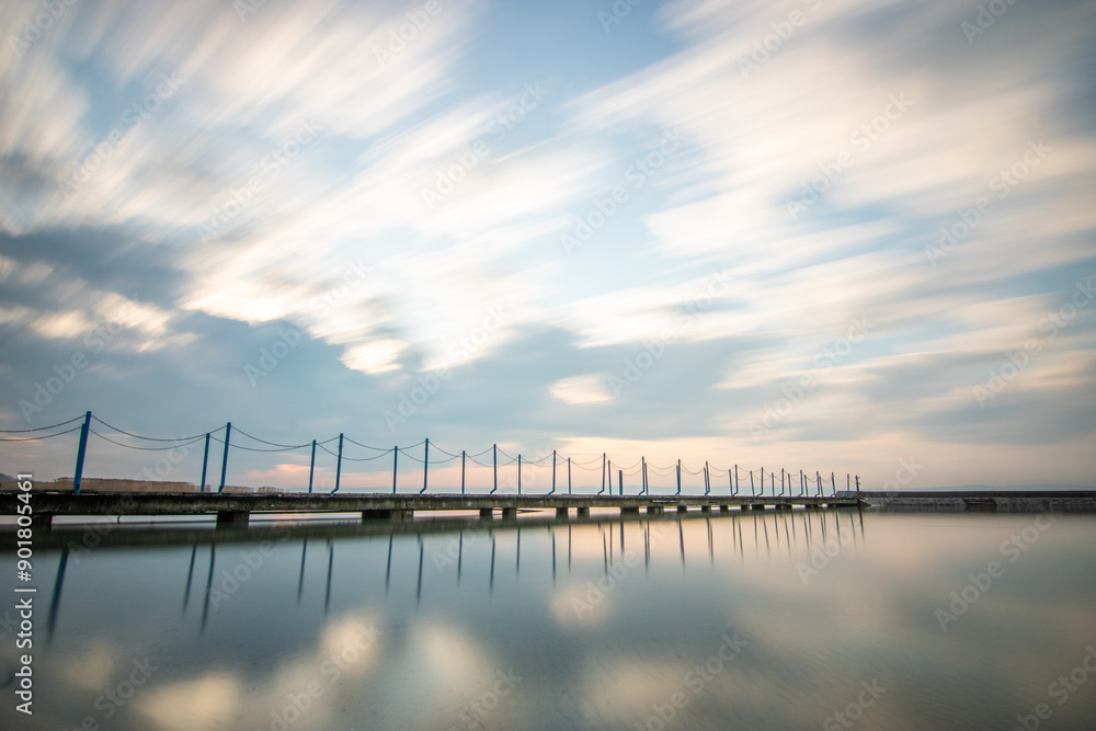 Water landscape taken from the shore of a calm lake. View over the reflecting water to the horizon in the sunset. Siofok harbor, Balaton, Hungary Water landscape taken from the shore of a calm lake. View over the reflecting water to the horizon in the sunset. Siofok harbor, Balaton, Hungary