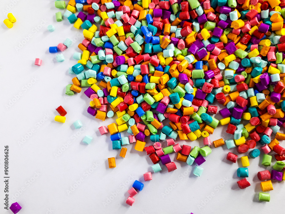Various colors of masterbatch granules mixed on a white background.Color pigment carrier polymers in the plastics industry Various colors of masterbatch granules mixed on a white background.Color pigment carrier polymers in the plastics industry