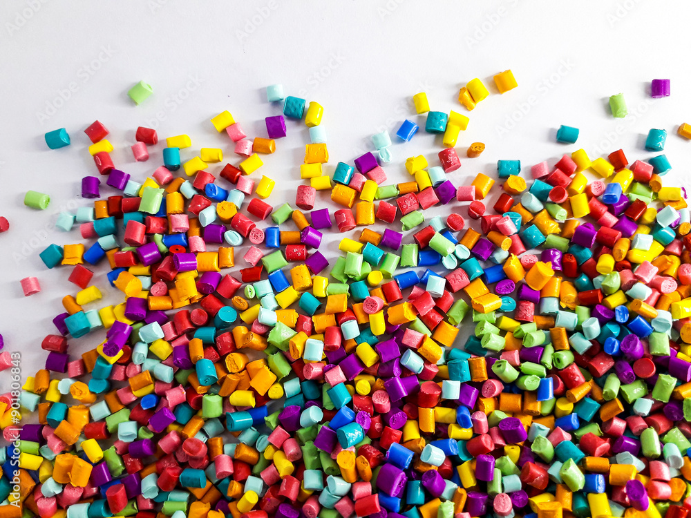 Various colors of masterbatch granules mixed on a white background.Color pigment carrier polymers in the plastics industry Various colors of masterbatch granules mixed on a white background.Color pigment carrier polymers in the plastics industry