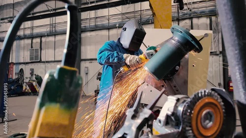 Welder using a grinder tool on industrial pipe 1