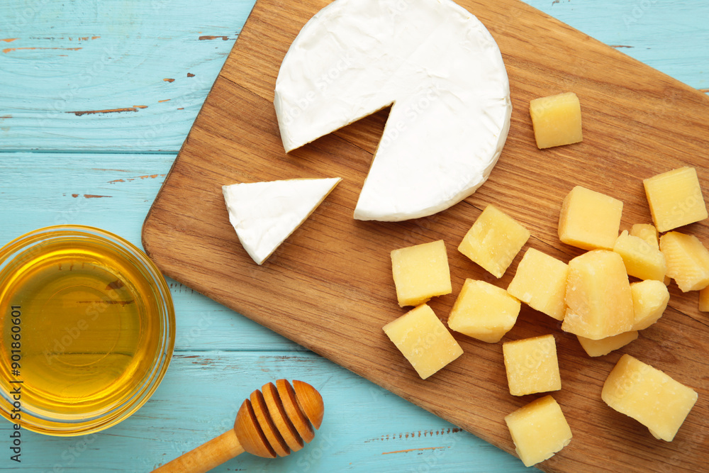 Honey with camembert and parmesan cheeses on cutting board Honey with camembert and parmesan cheeses on cutting board