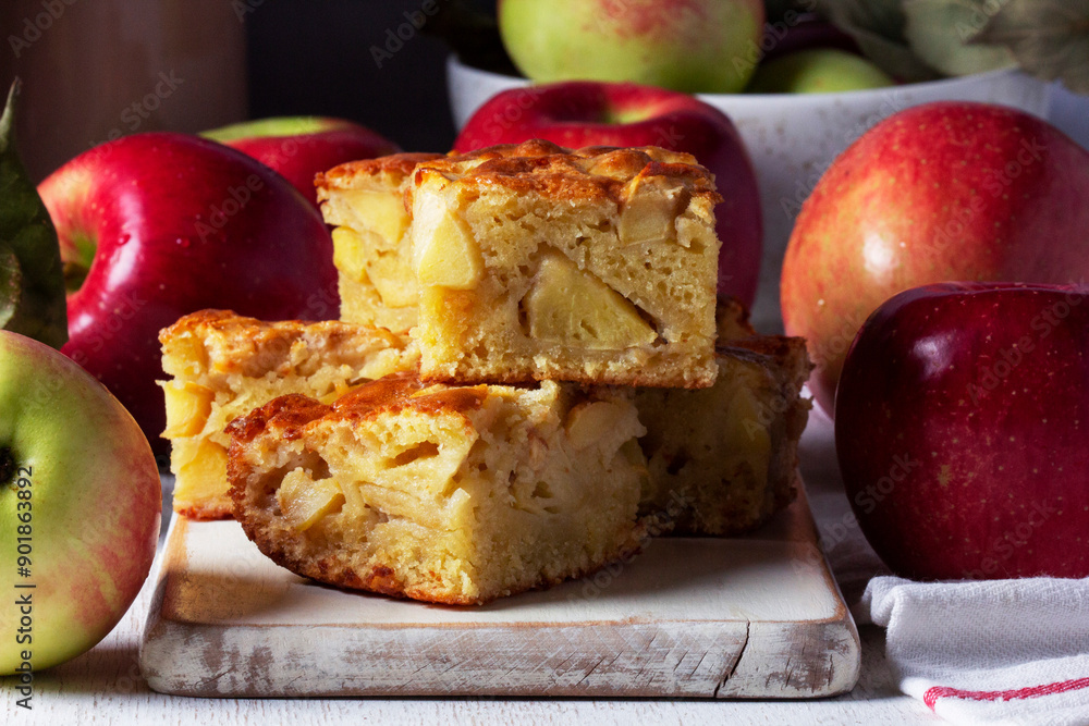Apple pie, apples and teapot served for tea. Traditional apple dessert.
