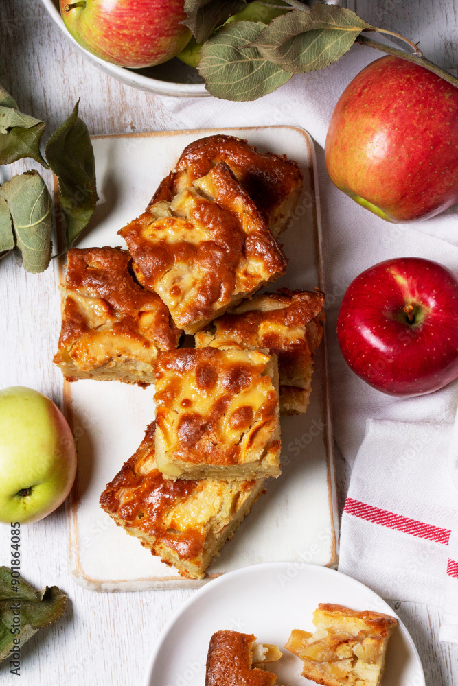 Apple pie, apples and teapot served for tea. Traditional apple dessert.