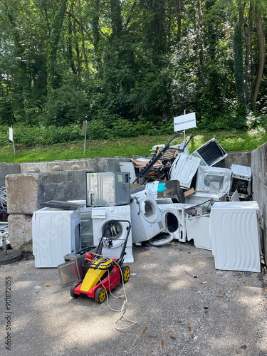 Defekte Waschmaschinen und Rasenmäher auf einer Sammelstelle beim Recyclinghof photo