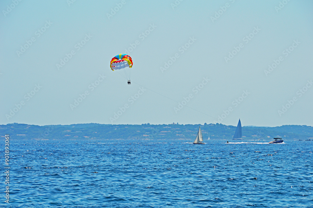 Three people on a colorful parasailed Three people on a colorful parasailed