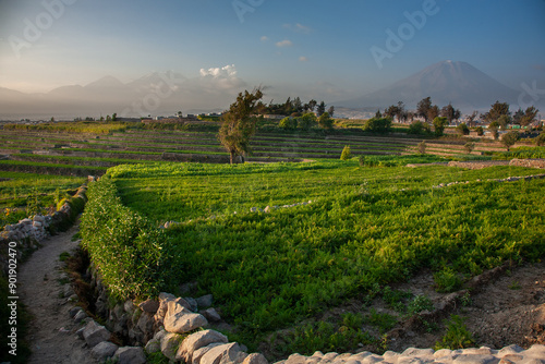 As the sun sets over Arequipa City, the sky transforms into a breathtaking display of warm hues, ranging from fiery oranges to soft purples.