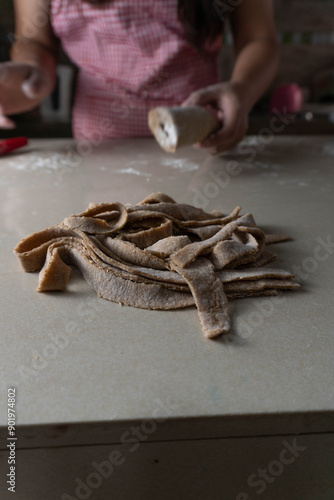 female hands cutting artisanal dough for artisanal pasta