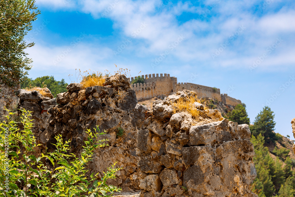 Fototapeta premium Landscape view old walls of fortress on Mediterranean coast. View of Alanya Castle, stone ruins in Alanya, Turkey