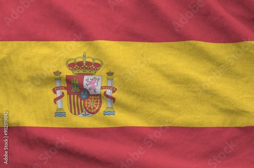 Spain flag depicted on folded wavy fabric of old cloth close up photo