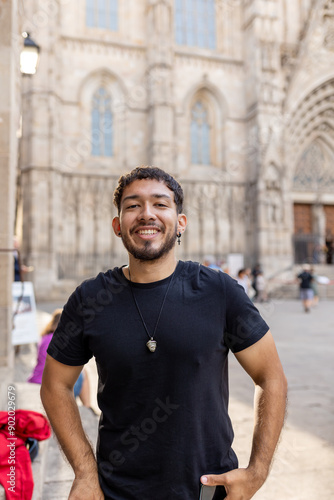 Canvas Print Young smiling Colombian man looking at camera on vacation at Barcelona Cathedral