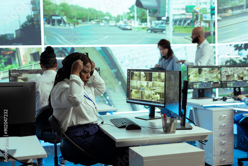 Tableau sur toile African american dispatch employee uses public satellite sensors to ensure safety in city streets, monitoring traffic via CCTV radar cameras at stop lights