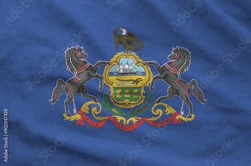 Pennsylvania US state flag depicted on folded wavy fabric of old cloth close up