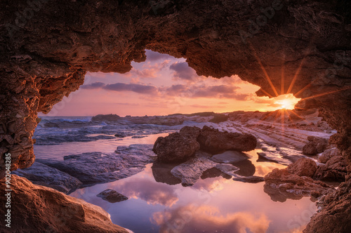 Sunset view from the sea cave. Sunset Framed by Coastal Rocks. Cyprus.