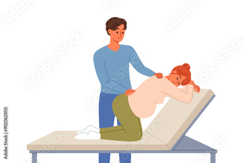 Man gives massage to pregnant woman kneeling on hospital bed waiting for labor to begin. Caring husband takes care of pregnant wife experiencing back pain while awaiting birth of child.