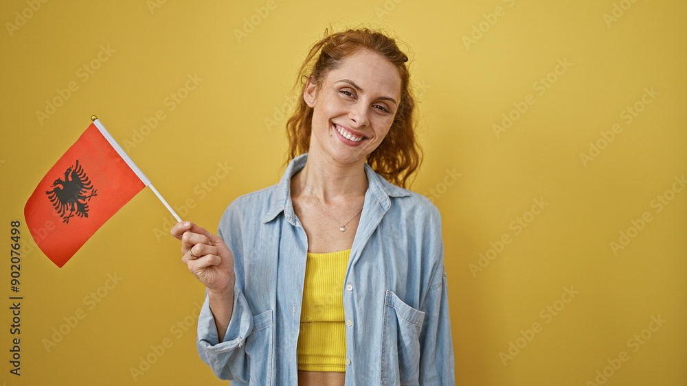 Smiling young woman holding an albanian flag against a yellow background, portraying national pride and happiness. Smiling young woman holding an albanian flag against a yellow background, portraying national pride and happiness.