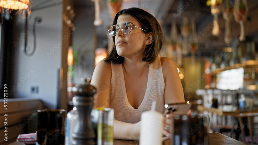 Young beautiful hispanic woman smiling sitting on the table at the restaurant Young beautiful hispanic woman smiling sitting on the table at the restaurant