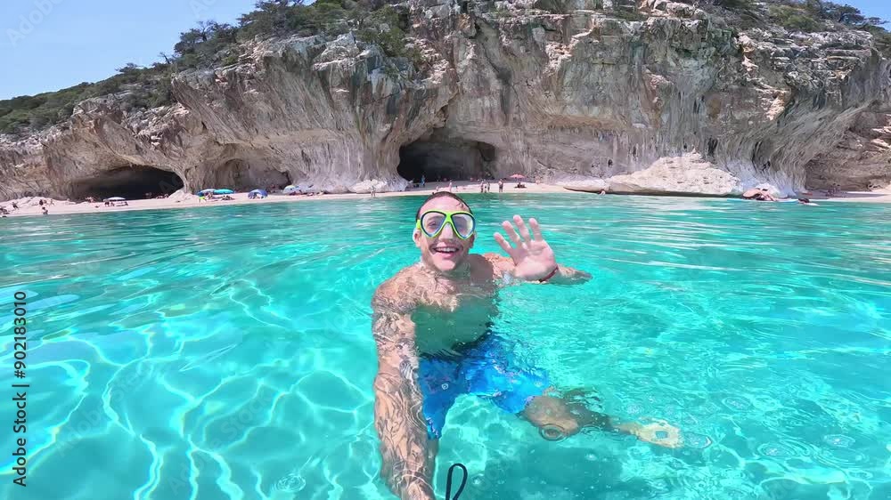 Young man holding camera taking selfie swimming in turquoise water looking camera smiling having fun. Happy cheerful male enjoying summer
Young man holding camera taking selfie swimming in turquoise water looking camera smiling having fun. Happy cheerful male enjoying summer