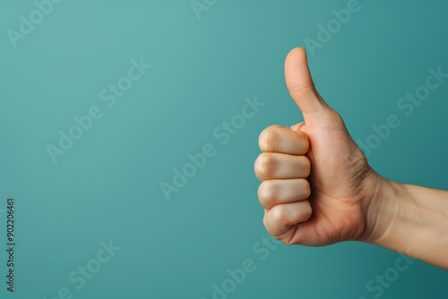 A close-up of a hand giving a thumbs-up gesture, symbolizing approval and positivity against a vibrant turquoise background.