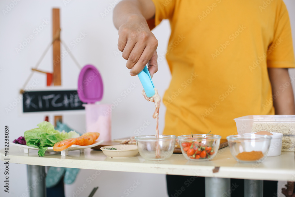 Man Takes Raw Chicken Meat Using Tongs For Mixes With Instant Noodles At Home Man Takes Raw Chicken Meat Using Tongs For Mixes With Instant Noodles At Home